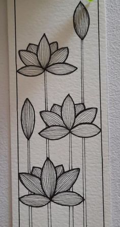 some black and white drawings with flowers on the wall in front of a green plant