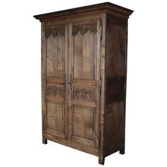 an old wooden armoire with carvings on the front and side doors, isolated against a white background