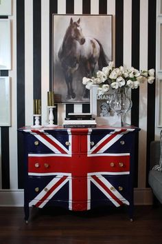 a british flag painted dresser in a living room with black and white stripes on the walls