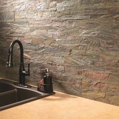 a kitchen sink sitting under a faucet next to a wall mounted soap dispenser