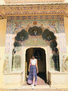 a woman standing in front of an ornate doorway