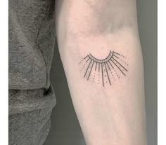 a woman's arm with a small sun tattoo on the left side of her arm