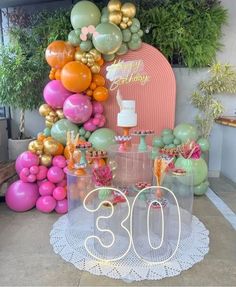 a table topped with balloons and cake next to a sign that says 80th birthday