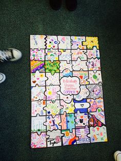 someone is standing on the floor next to a large puzzle board with words written all over it