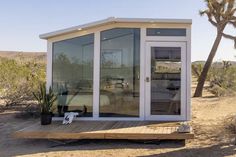 a small white building sitting in the middle of a desert