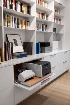 a printer on a desk in front of bookshelves