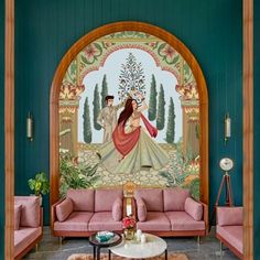 a living room filled with pink couches next to a large painting on the wall