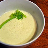 a white bowl filled with cream and garnish on top of a wooden table