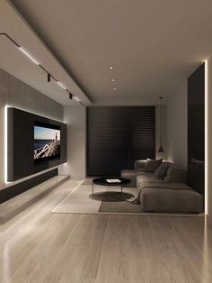 a modern living room with wood flooring and white walls is lit by recessed lighting