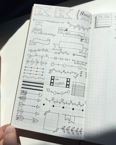 someone is holding up a notebook with doodles on the pages and writing in it