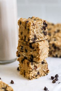 three oatmeal bars stacked on top of each other next to a glass of milk