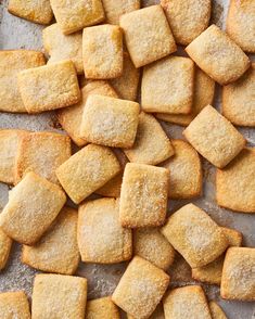 small pieces of sugary bread on a baking sheet with powdered sugar sprinkled on top