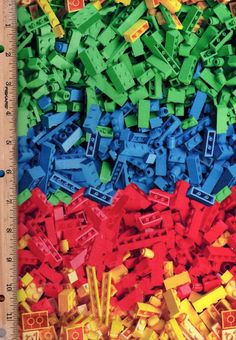 a large pile of legos sitting next to a ruler