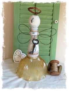 a glass bottle sitting on top of a table next to a spool of thread