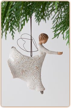 a white ornament hanging from a christmas tree with a little boy on it