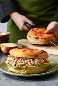 a person cutting into a sandwich on top of a plate