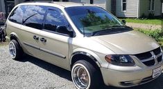 a beige van parked in front of a house