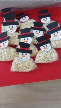 snowmen made out of rice krispy kreme treats on a red tray