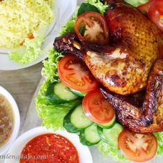 a chicken and vegetables on a platter with sauces next to the plate full of food