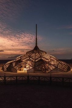 a building that is lit up in the dark at night with lights on it's roof