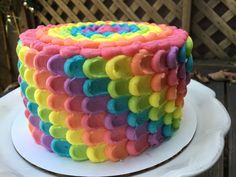 a multicolored cake sitting on top of a white plate