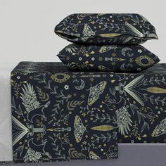 three pillow cases are stacked on top of each other, one is black and the other is gold