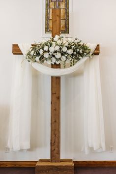 a cross decorated with flowers and greenery