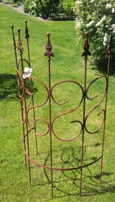 an iron garden plant stand in the grass