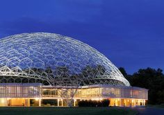 a large glass dome building lit up at night