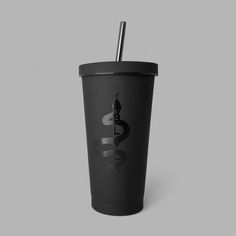 a black tumbler cup with a straw sticking out of the top, on a gray background