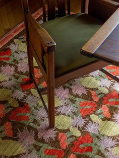 a wooden chair sitting on top of a colorful rug