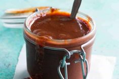 a glass jar filled with chocolate pudding on top of a white napkin and blue table cloth