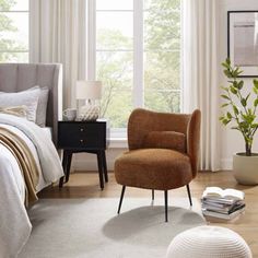 a bedroom with a bed, chair and window in it's centerpieces