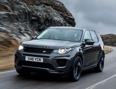 a grey range rover driving down a mountain road