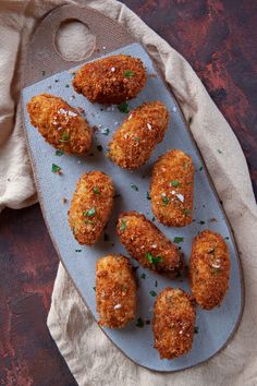 some fried food is on a plate with napkins and a cloth next to it