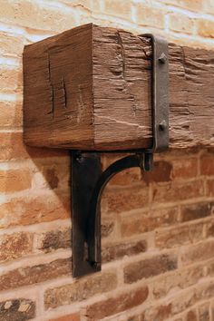 a brick wall with a wooden shelf and metal brackets attached to the side of it