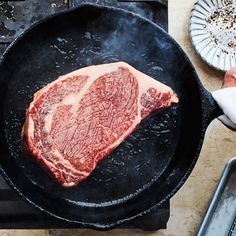 a steak is cooking in a skillet on the stove