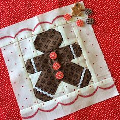 a close up of a piece of fabric on a red table cloth with a teddy bear