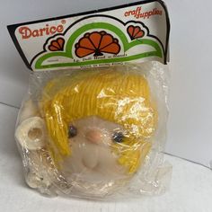 a small plastic toy with a yellow hat on it's head in a plastic bag