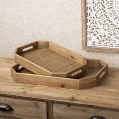 a wooden tray with handles on top of a dresser