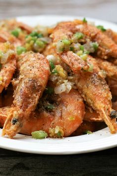 a white plate topped with fried shrimp and vegetables