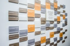 the wall is covered with many different colors and sizes of business cards on it's sides