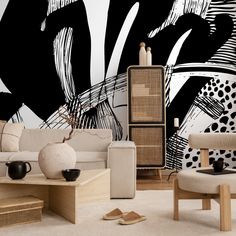 a living room with black and white wallpaper, furniture and art on the walls