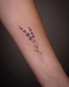 small lavender flower tattoo on the arm