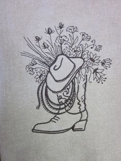 a drawing of a cowboy boot with flowers in it's hat on a piece of cloth