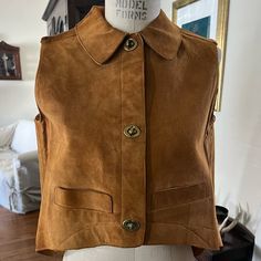 This Bonnie Cashin For Sills & Co. Collared Vest Is From Her 1970-1971 F/W Collection. It Is An Iconic Piece From The Inventive American Designer. A Similar Piece Is Featured In A 1970 Editorial And Currently Held In The Met's Permanent Collection. It Was Made Of A Tan Unlined Suede In A Parabola Cut, Doing Up The Front With Three Of Cashin's Signature Twist Locks. The Suede Does Show Some Wear, Mainly On The Top Of Shoulders. Neck Area Has A Crack. There Is Also Some Patina To The Twist Locks. Please Zoom In On The Photos. The Suede Remains Supple And The Jacket Is Overall In Good Condition For Its Age! Bonnie Cashin, Collar Vest, Suede Vest, Vintage Suede, American Design, Patina, 1970s, Overalls, Editorial