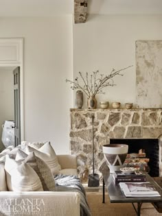 a living room filled with furniture and a fire place in front of a stone fireplace