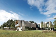 a modern house in the middle of a grassy field