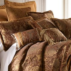 the comforter is made up with many different types of pillows and blankets on it