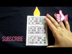 someone holding up a piece of paper with a lit candle on it and the word subscribe written in pink